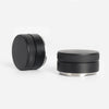 A black precision espresso distribution tool with a silver base and textured top.