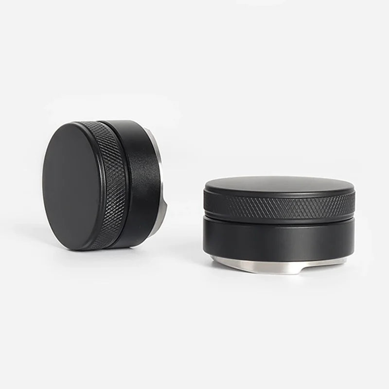 A black precision espresso distribution tool with a silver base and textured top.