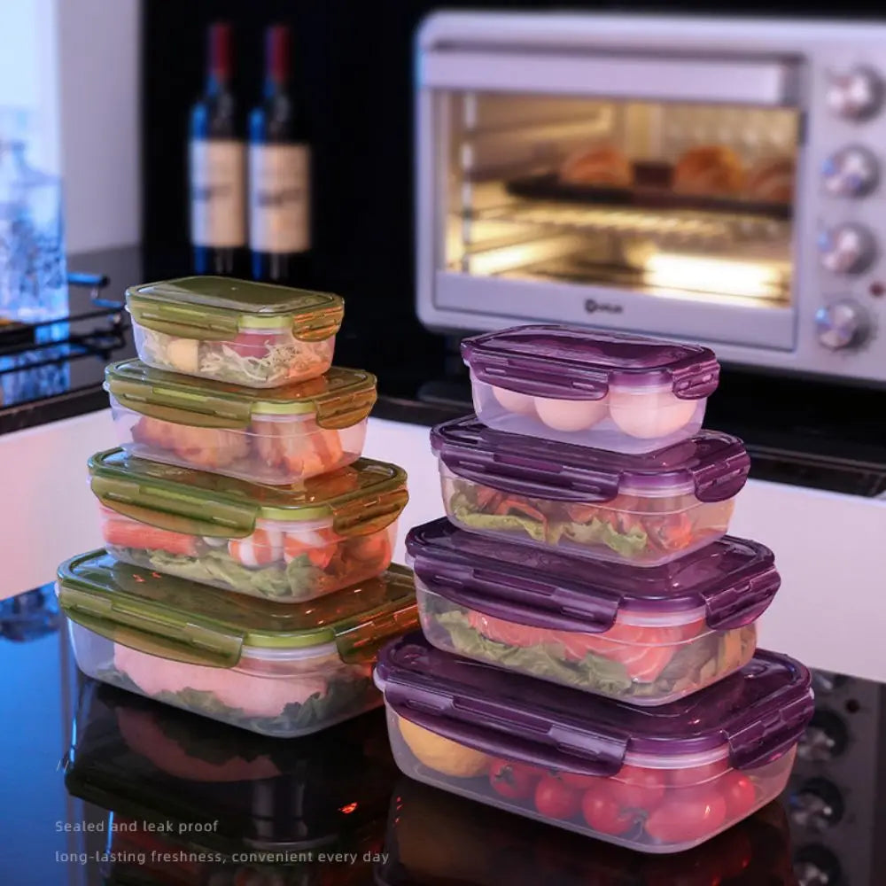 Stack of purple and green airtight food storage containers on a black surface next to a microwave oven.