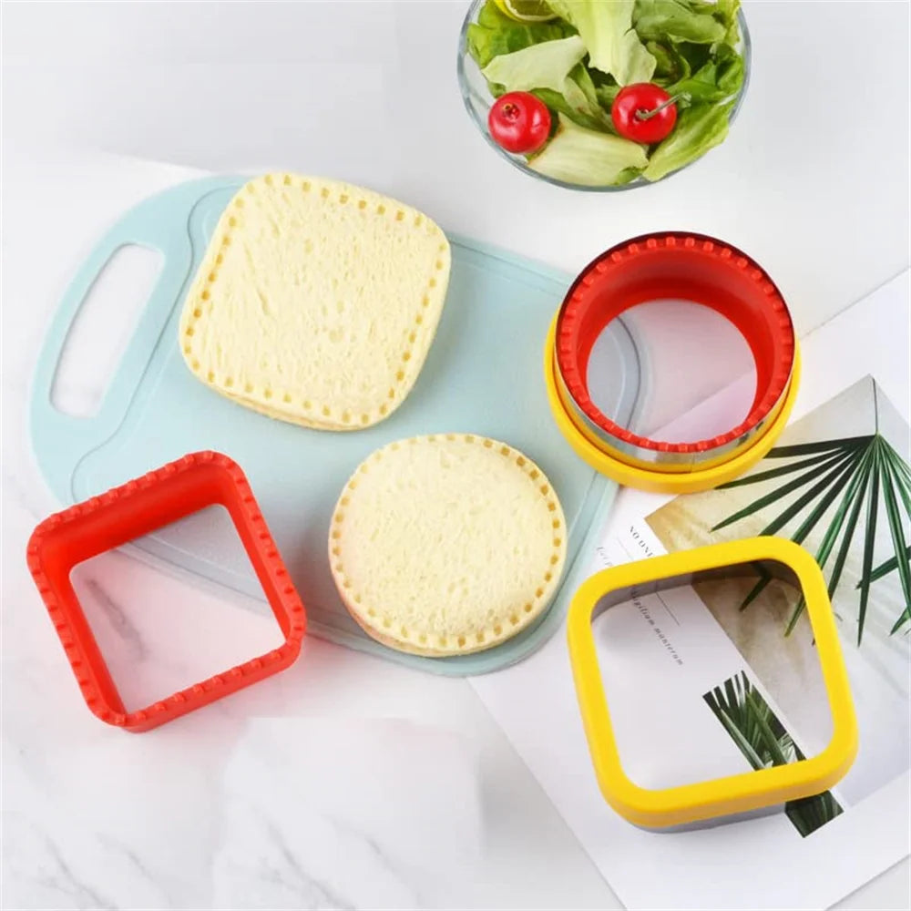 A set of geometric sandwich cutters in red and yellow plastic, with a sandwich and a salad visible.