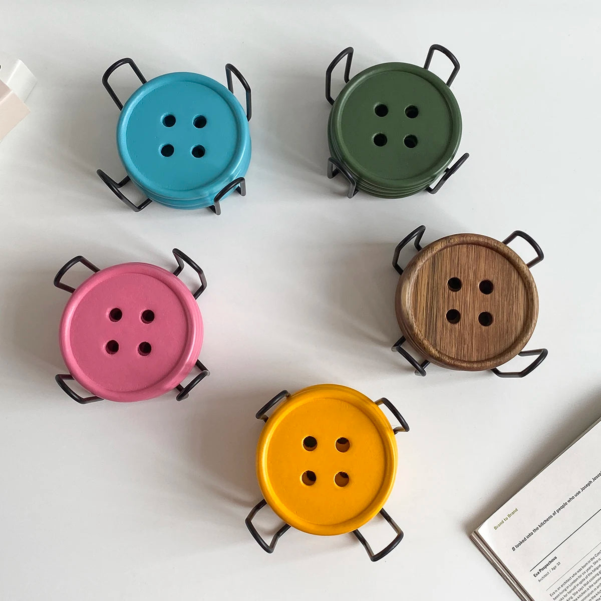 A set of six decorative wooden coasters, colored teal, olive green, pink, and yellow, each with an iron rack.