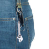 A close-up of a pair of metal tools hanging from a denim pocket, showing a spanner wrench and chain.