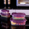 Stackable airtight purple plastic storage boxes containing fresh produce on a black surface.