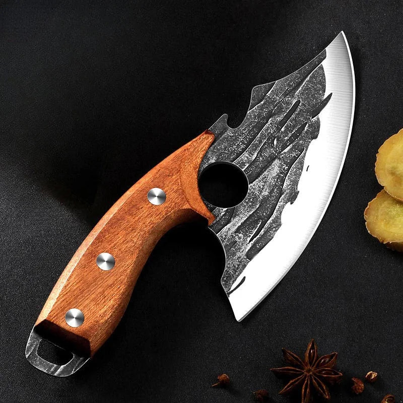A hand-forged boning kitchen knife with a silver blade and wooden handle rests on a dark surface.