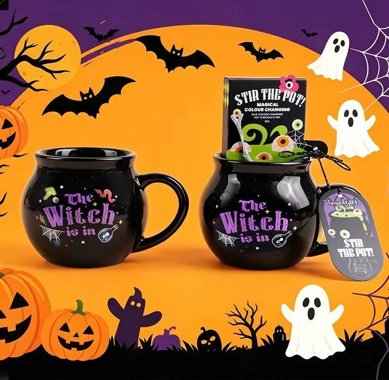 A black cauldron mug with a witch theme and a magic potion sits next to a box of stir the pot color changing magic.