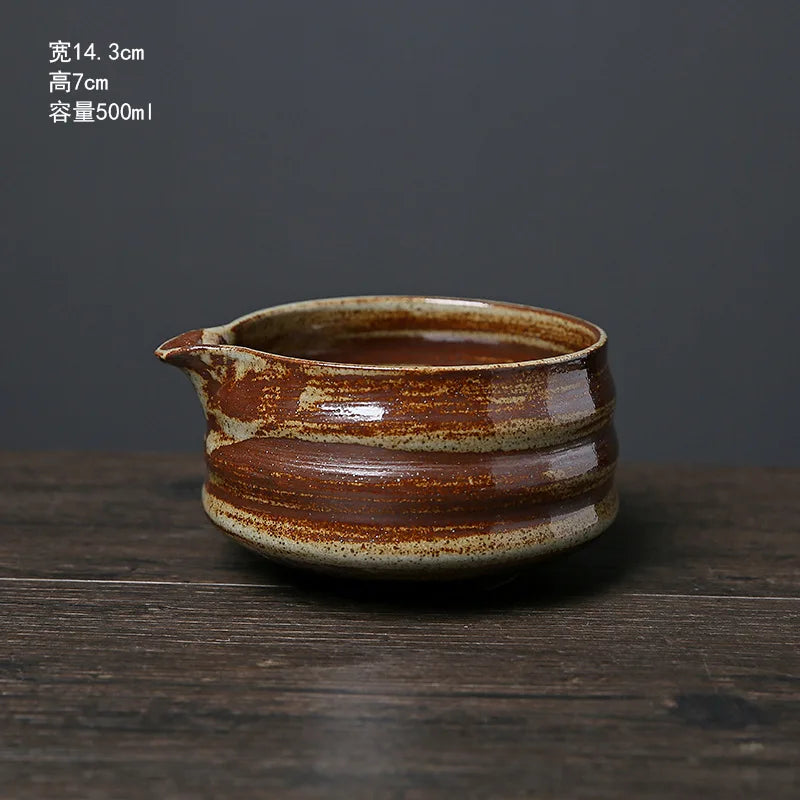 A ceramic matcha whisk pot with an earthy brown glaze sits on a dark wooden surface.