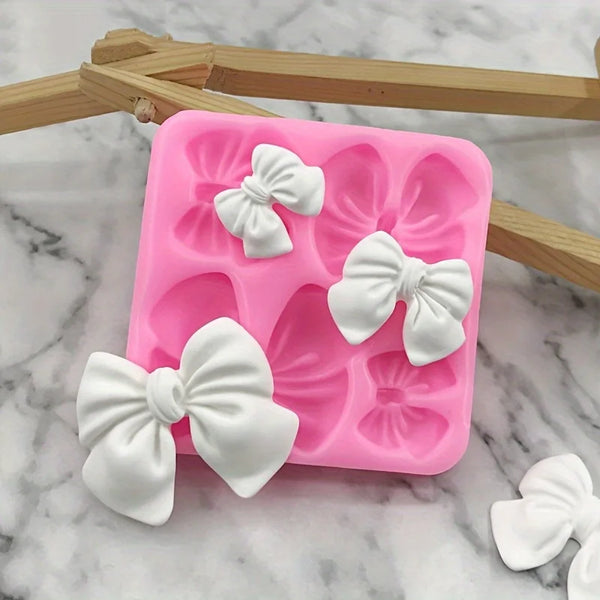 Pinkes Silikonform mit Blumenformen zum Backen, mit weißen Schleifen-Designs.