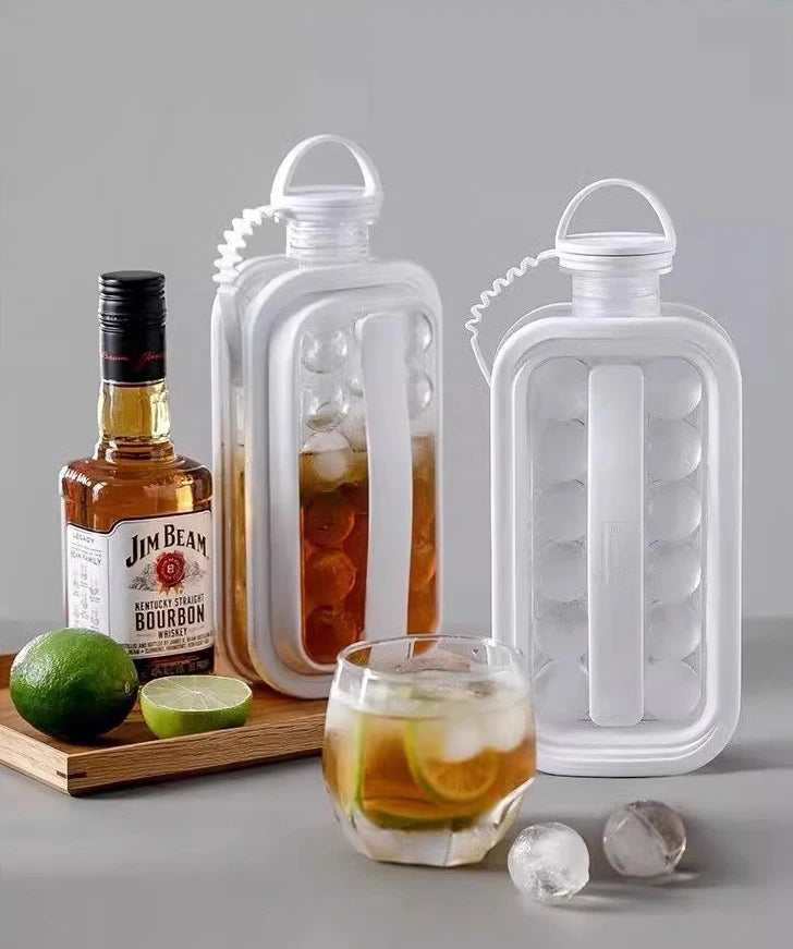 A white portable ice cube maker with a bottle design sits next to a bottle of Jim Beam bourbon and a lime.