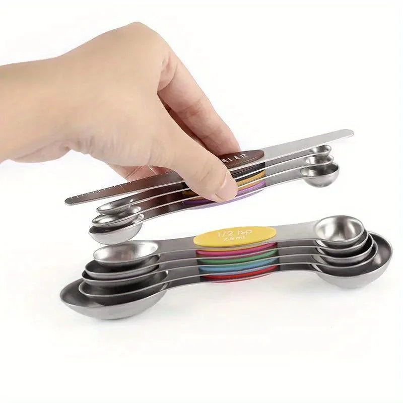 A hand holds a 9-piece stainless steel measuring spoon set with magnetic suction, featuring multiple spoons in various colors