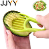 A hand holds a green avocado half with a yellow silicone tool used to slice or core the fruit.