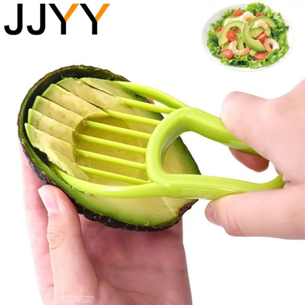 Eine Hand hält eine halbe grüne Avocado mit einem gelben Silikonwerkzeug zum Schneiden oder Entkernen des Fruchtes.
