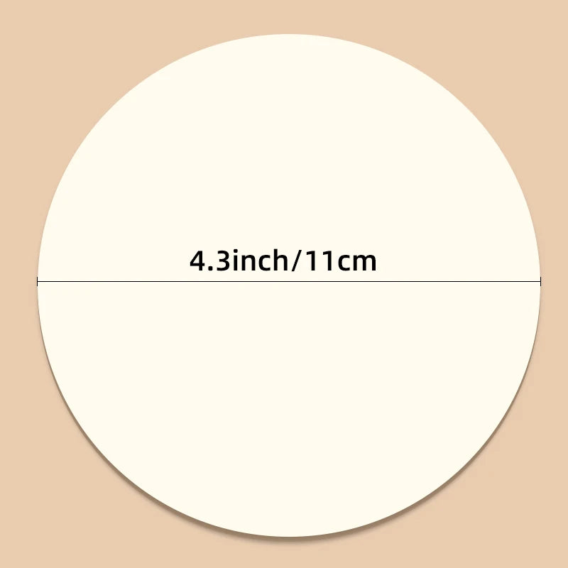 A white circular sheet of non-stick baking paper measuring 4.3 inches or 11 cm.
