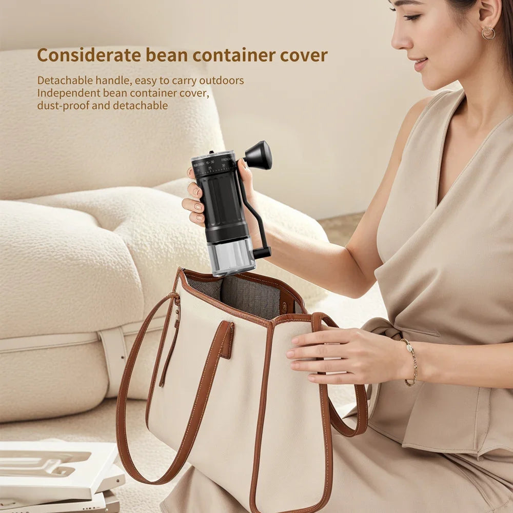 A woman holds a black manual ceramic coffee grinder with an adjustable scale and a beige canvas bag.