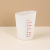A clear silicone measuring cup with volume markings is shown against a light background.