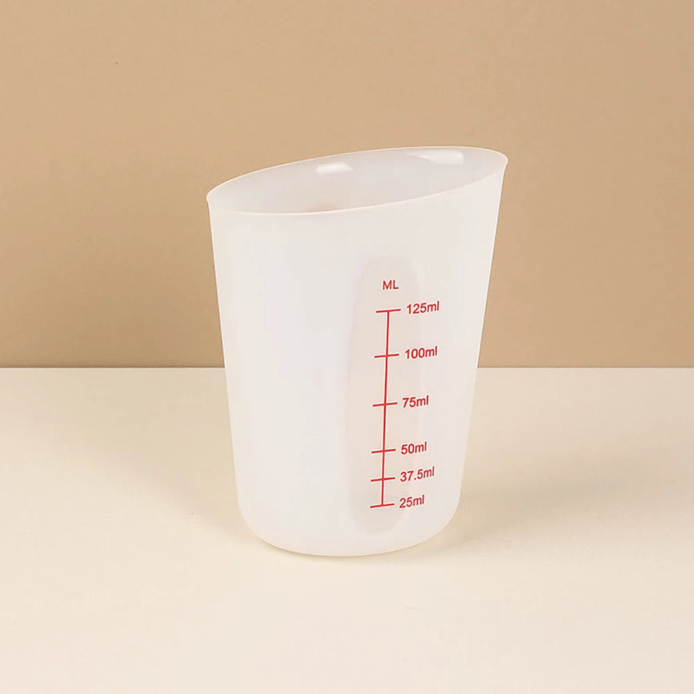 A clear silicone measuring cup with volume markings is shown against a light background.