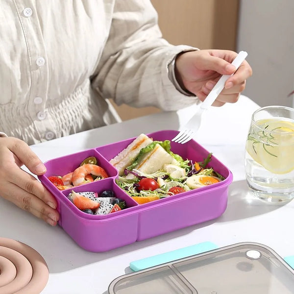 Lila, abnehmbare Bento-Lunchbox mit Essen und Gabel, die von einer Person gehalten wird.