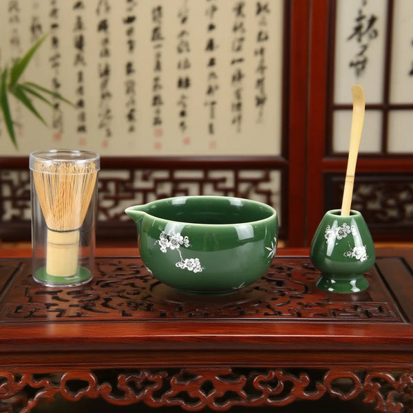 Grüne Keramiktasse für Matcha und Bambus-Pinsel auf Holztablett mit traditioneller japanischer Kalligrafie
