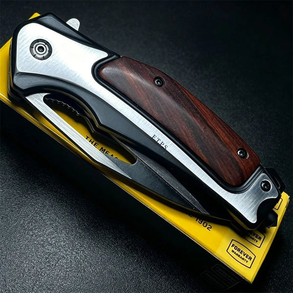 A folding knife with a dark wood handle and silver metal frame is shown on a black surface.