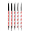A set of professional nail art brushes with dotting tools and a palette, featuring pink and white handles.