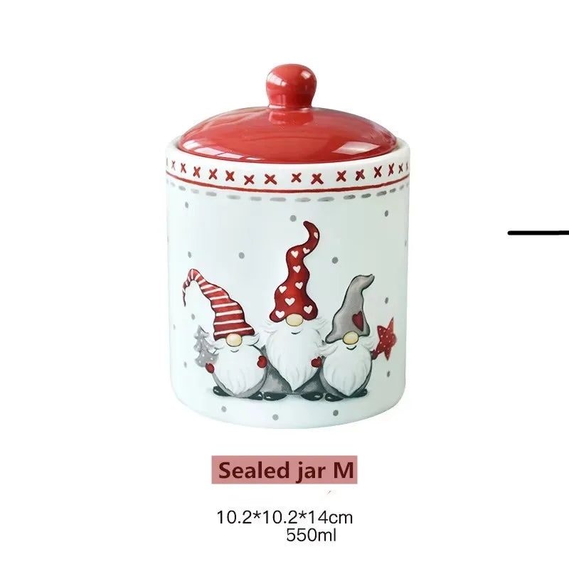 A white ceramic jar with a red lid decorated with an X pattern and featuring illustrations of three Santa figures.