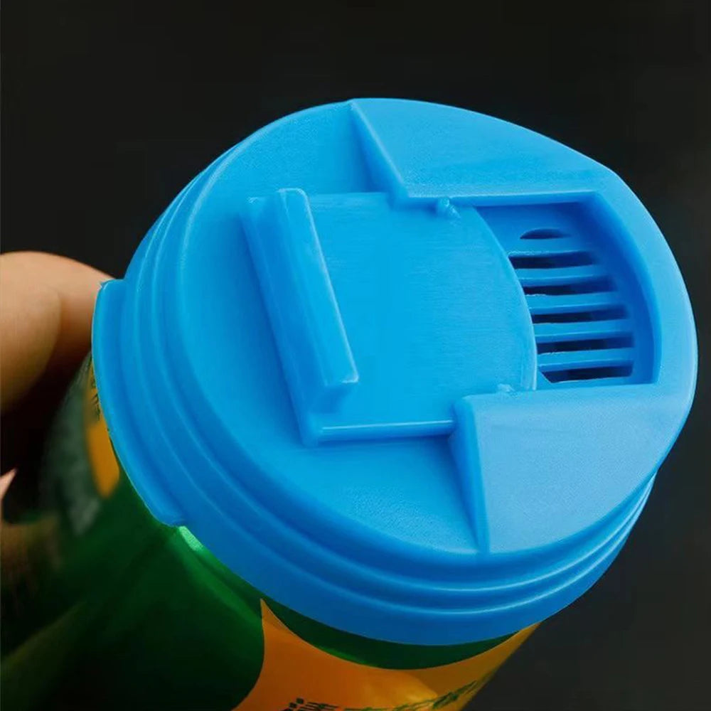 A close-up of a blue reusable leakproof soda can lid being held, showing its textured surface and slotted design.