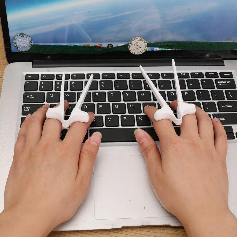 A pair of white finger guard chopsticks resting on a black laptop keyboard.