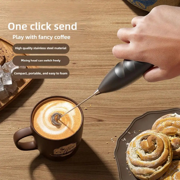 Eine Hand benutzt einen Handmixer zum Aufschäumen von Kaffee in einer Tasse.