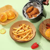 A collection of food items including bread rolls, french fries, and a piece of fruit arranged on a light green surface.