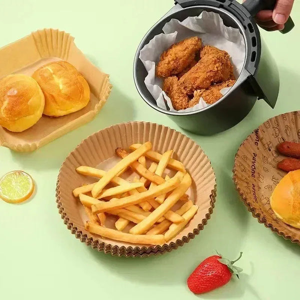 A collection of food items including bread rolls, french fries, and a piece of fruit arranged on a light green surface.