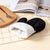 A pair of black and white heavy-duty oven and baking mitts resting on a wire grid next to a wooden board.