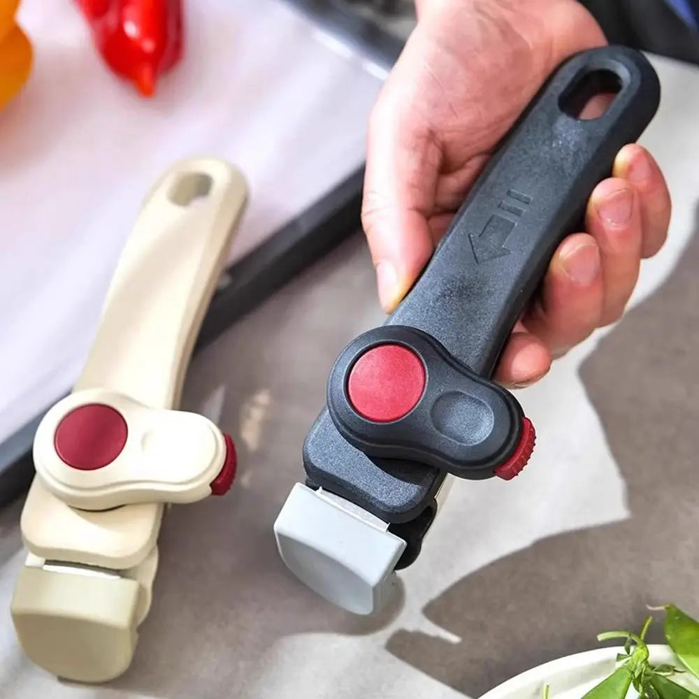 A hand holds a detachable cookware handle clip, showing the grip and clamping mechanism.