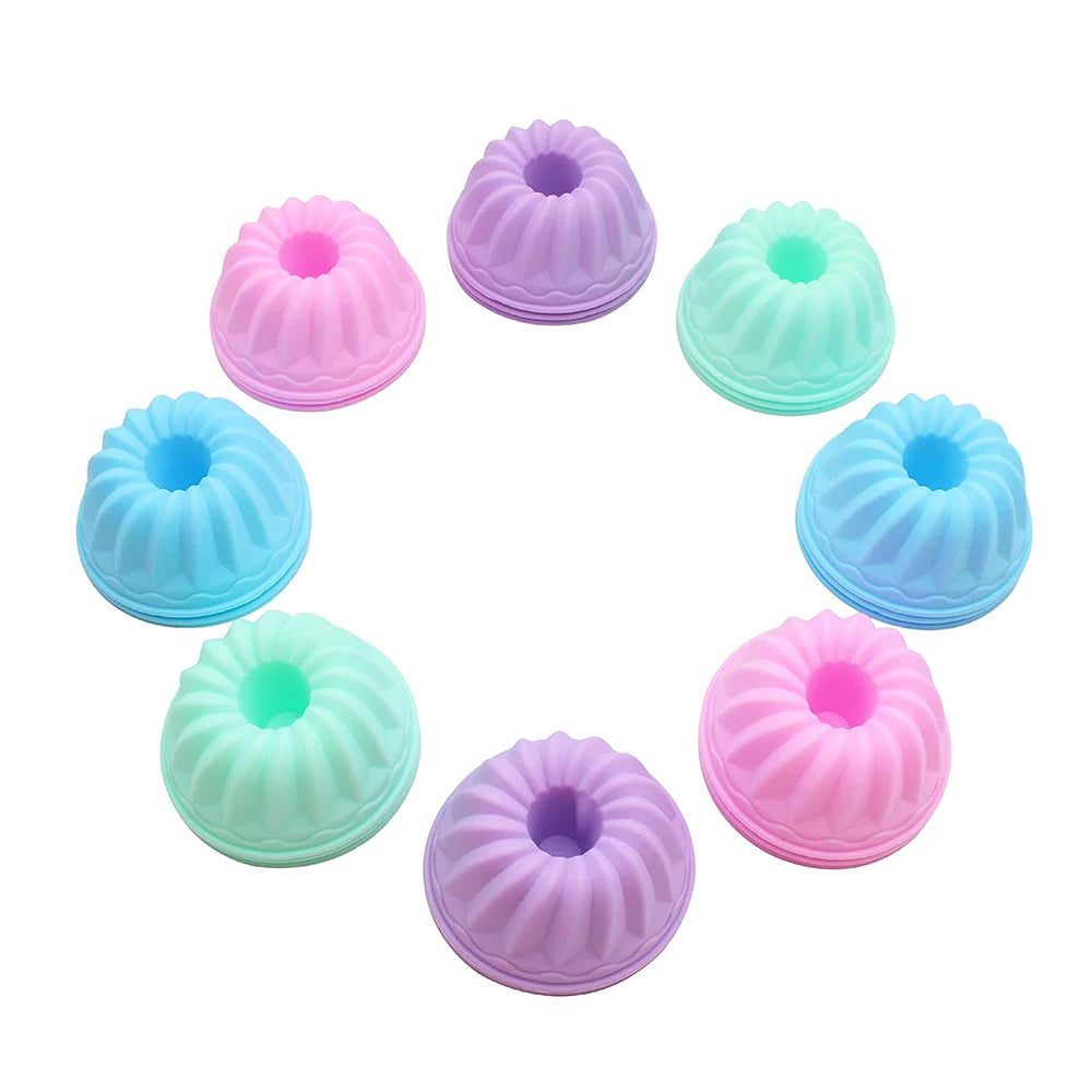 A set of twelve silicone baking molds in various shades of pink and blue arranged in a circle.