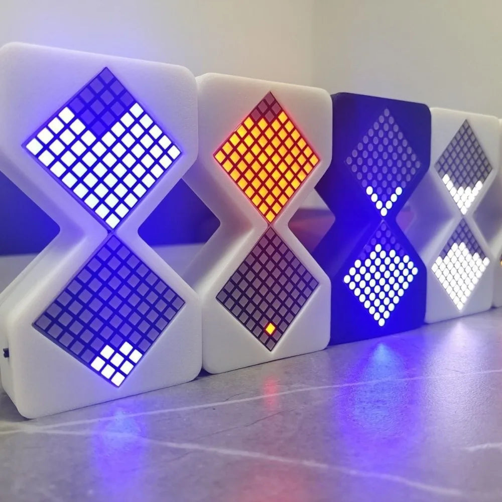 A row of white LED digital hourglass timers displaying various colored light patterns on a reflective surface.