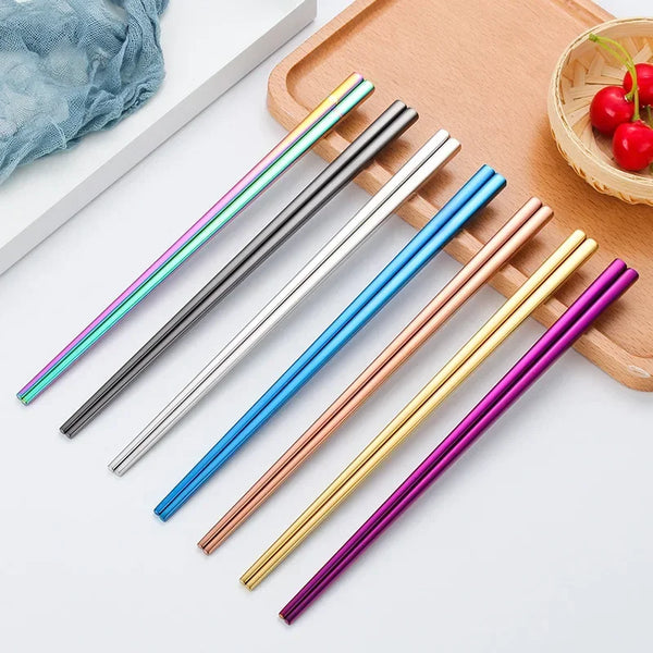 Set aus neun wiederverwendbaren Edelstahl-Stäbchen in verschiedenen Farben, darunter blau, silber, gold und lila, auf einem H
