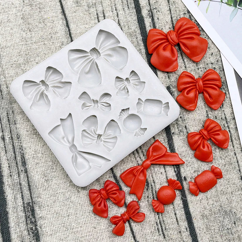 A silicone baking mold set featuring various decorative bows and flowers in a matte white color.
