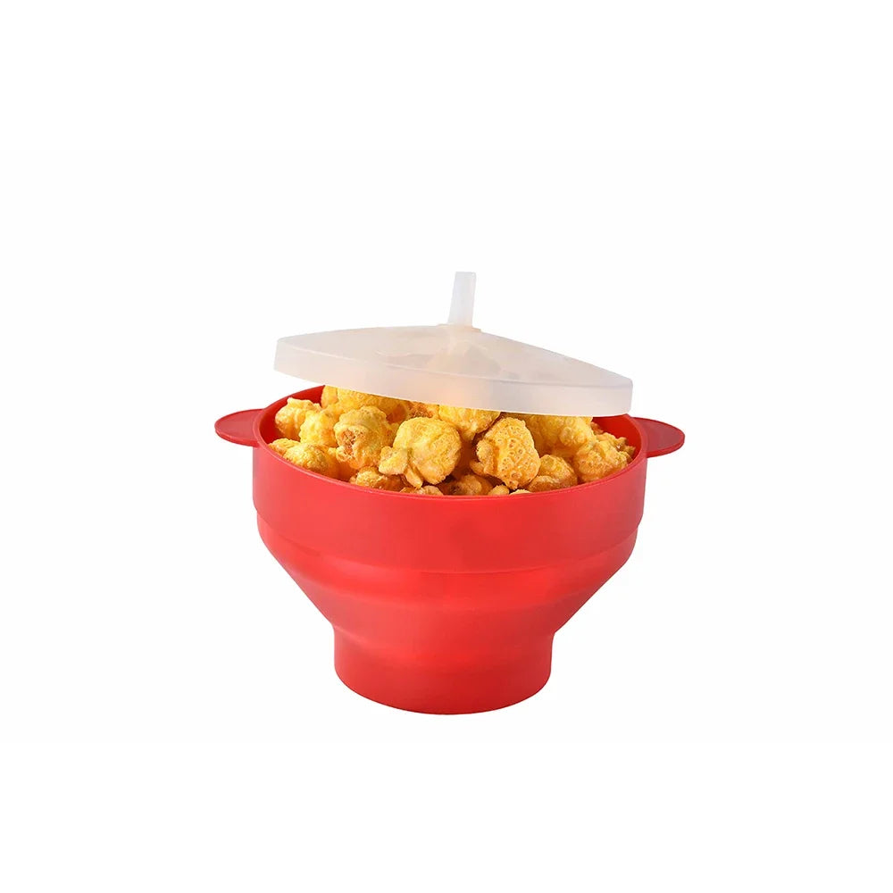 A red silicone microwave popcorn bowl with a clear lid and a serving of popped corn inside.