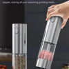 A set of two automatic rechargeable salt and pepper grinders, one silver and one clear glass, shown in use.