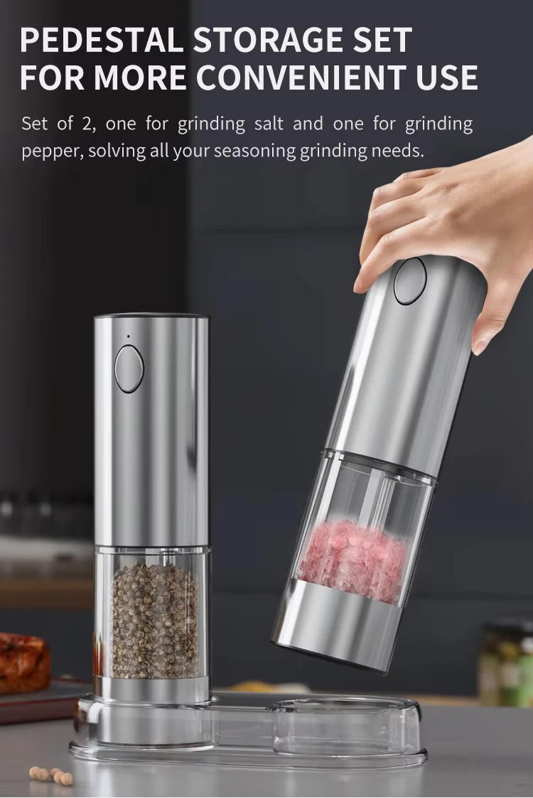 A set of two automatic rechargeable salt and pepper grinders, one silver and one clear glass, shown in use.