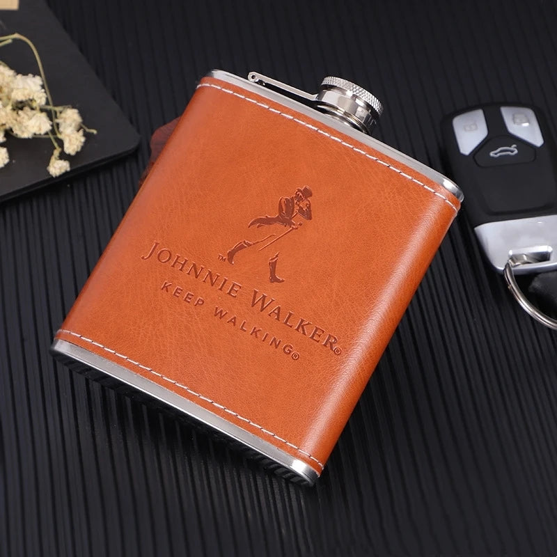 A brown leather flask with a silver cap and engraving is shown on a dark surface.