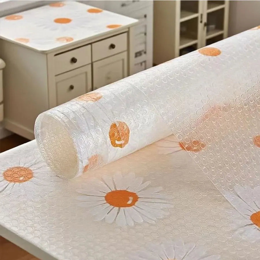 Almohadilla protectora de EVA blanca y resistente al agua con estampados de margaritas naranjas sobre una tapa de mueble de m