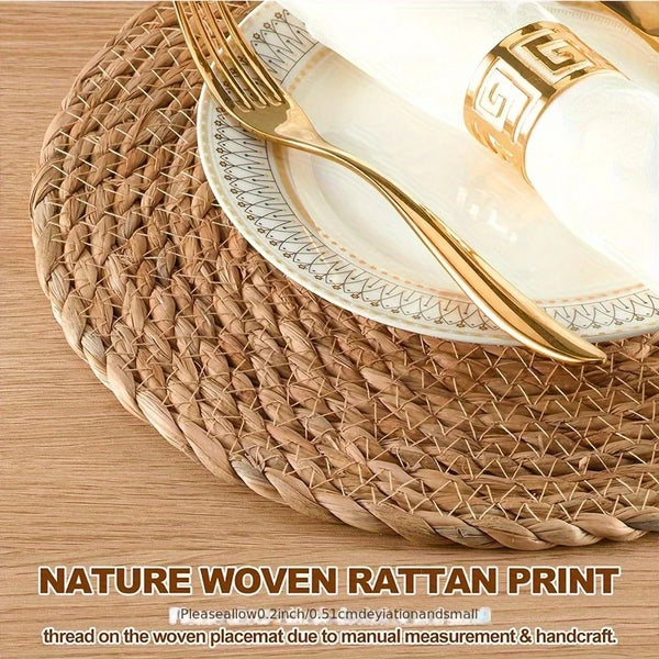 A set of gold-rimmed plates and cutlery resting on a natural woven rattan placemat.