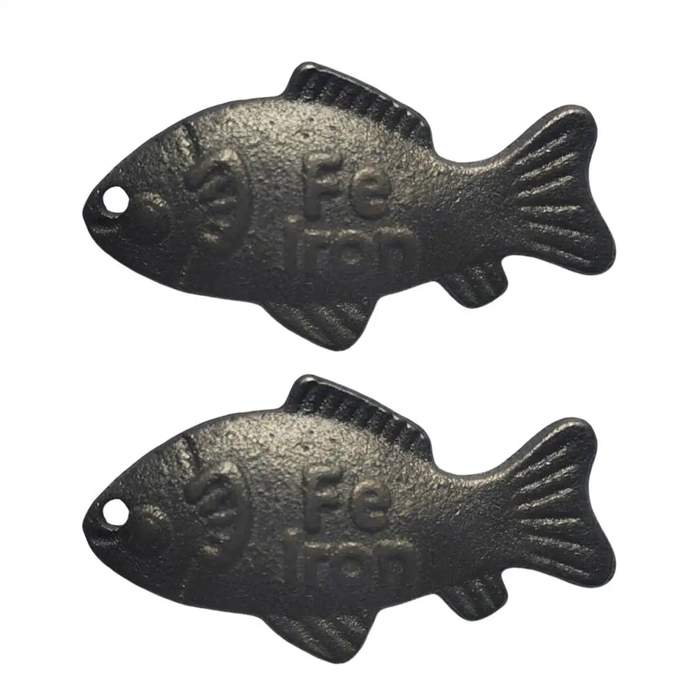 A black reusable iron fish kitchen accessory set with a textured, fish-shaped design.