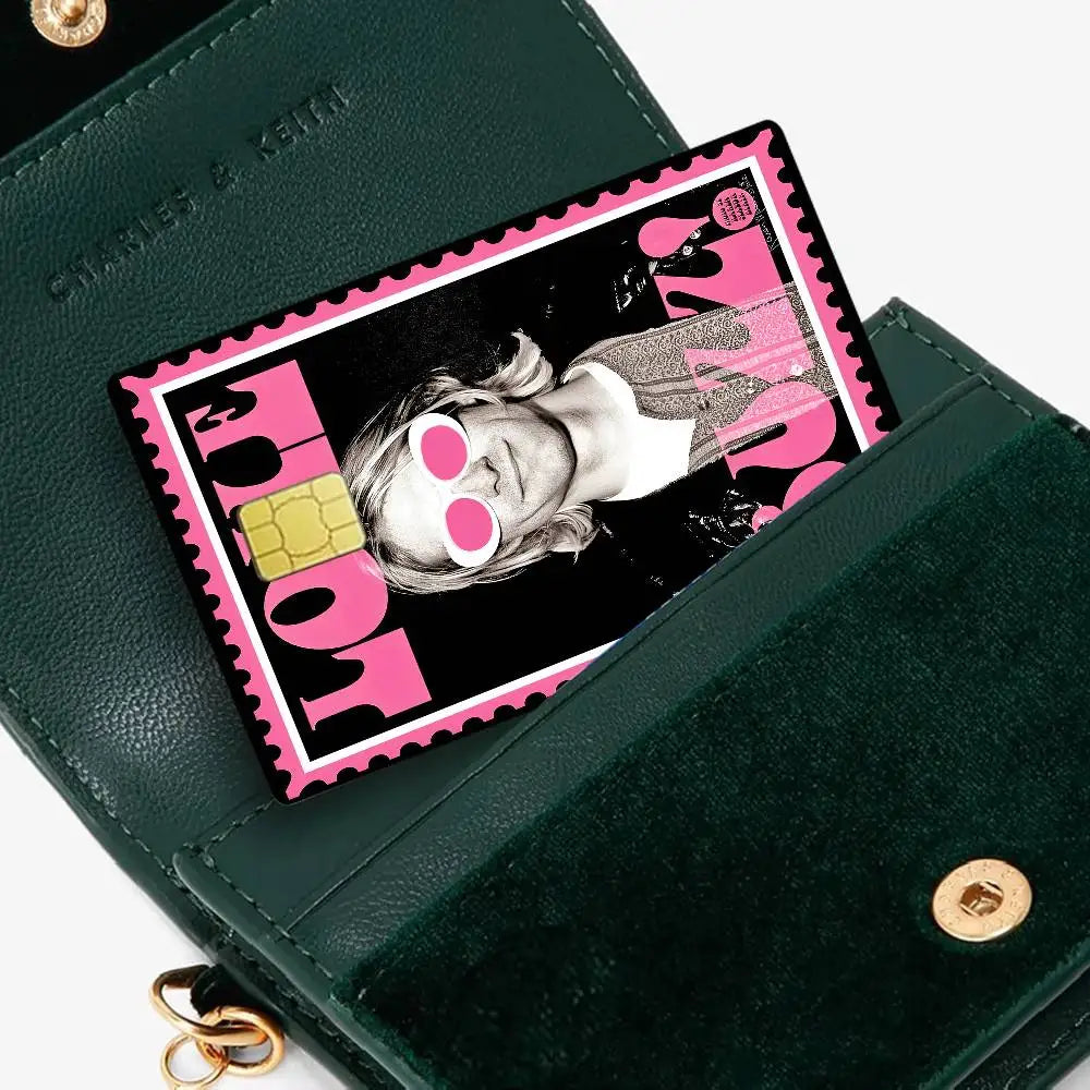 A dark green wallet features a pink and black rectangular debit card with an anime-style graphic.