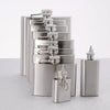A set of stainless steel hip flasks stacked vertically with various sized flasks and a funnel.