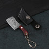 A set of black leather pocket mini knives featuring a Damascus pattern blade with a wooden handle and chain.