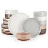 A collection of stoneware dinnerware plates and bowls in various muted earth tones, including white, gray, and terracotta.