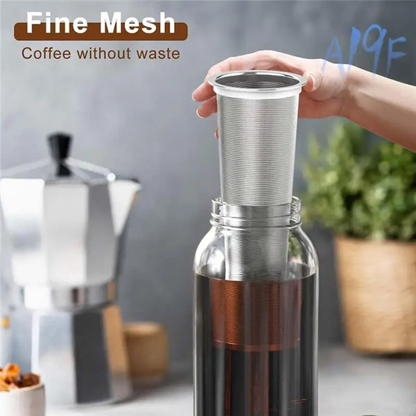 Eine Hand hält einen feinen Siebfilter für Cold Brew, der Kaffee ohne Verschwendung zubereitet.