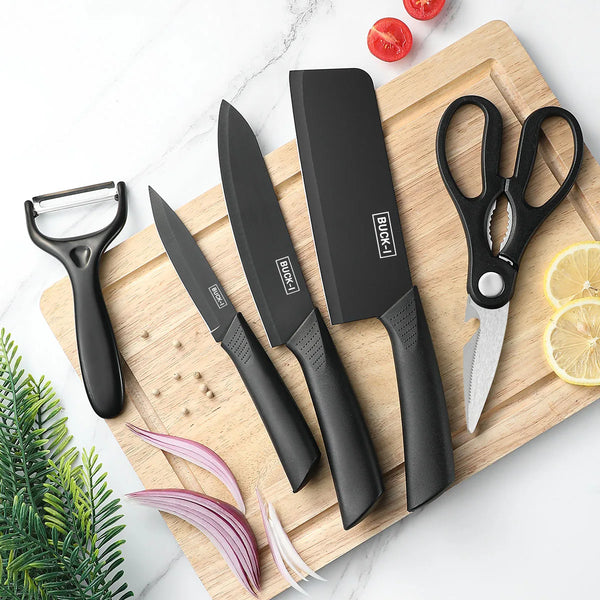 A set of black steel kitchen knives, including a chef knife and utility knife, displayed on a wooden cutting board.