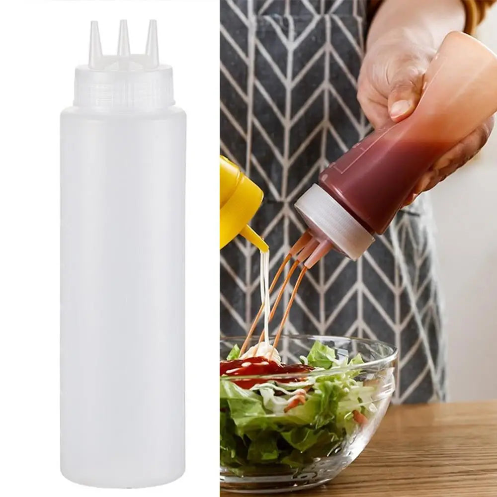 A hand is squeezing a dark red sauce from a squeeze bottle into a glass of salad.