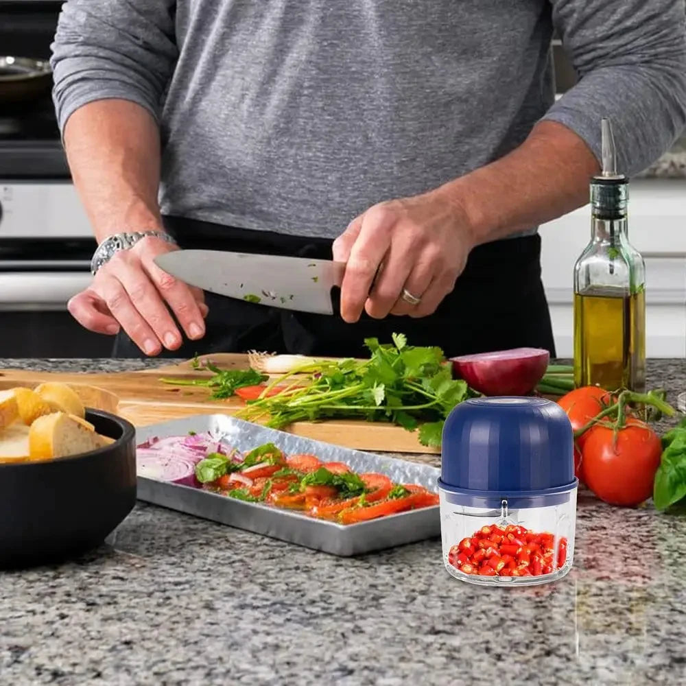 A person is using a knife to cut herbs and vegetables on a wooden cutting board.